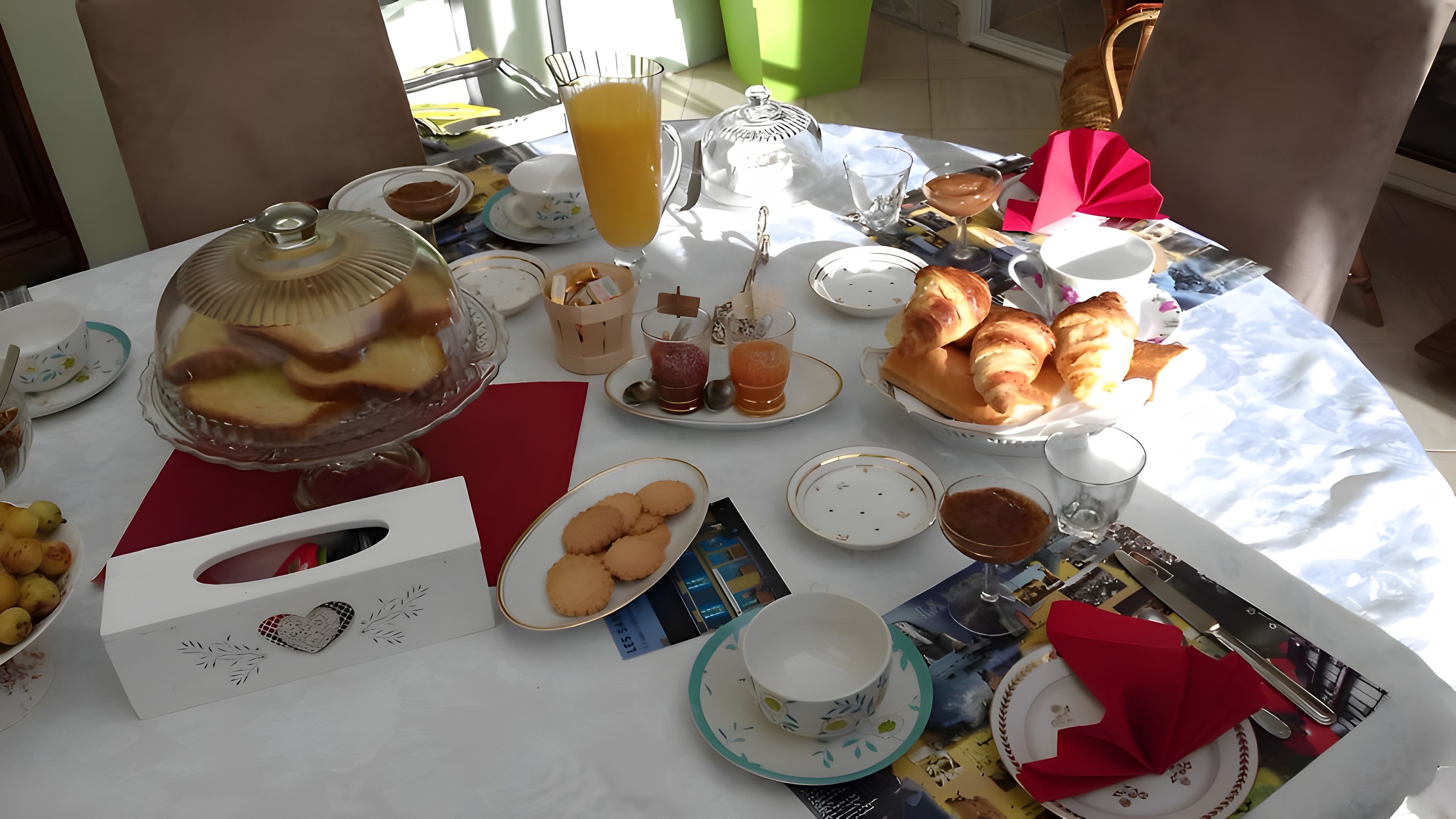 Mesa de café da manhã com diversos alimentos, incluindo doces, frutas e bebidas.