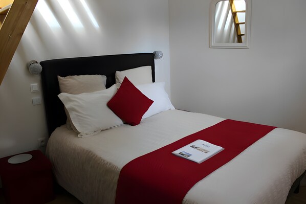 A neatly made bed with a red accent pillow, a white throw blanket, and a magazine on the bed. - Guest Room 'Entre Mer Et Terre - Chambre Rubis' with Shared Garden and Wi-Fi (Bazenville)