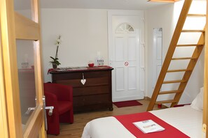 A bedroom with a bed, a dresser, a red chair, a desk with a plant, and a ladder. - Guest Room 'Entre Mer Et Terre - Chambre Rubis' with Shared Garden and Wi-Fi (Bazenville)