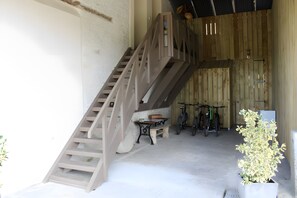 A staircase leading to a covered area with bicycles and a bench.