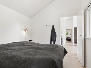 A modern bedroom with a large bed, a standing lamp, and a door leading to another room. - "Felicita" - 800m from the sea by Interhome (Højby)