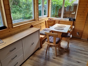Un interior de madera con una mesa de comedor, sillas y un banco.