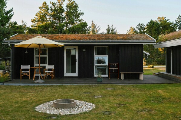 A modern house with a covered patio, a fire pit, and a small deck. - Summer house with two terraces near Rødhus Strand (Pandrup)
