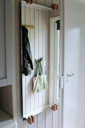 A room with a white door, a coat rack with a jacket, and a bag hanging on the wall. - Summer house with two terraces near Rødhus Strand (Pandrup)