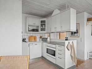 A modern kitchen with white cabinetry, a built-in oven, and a microwave. - "Swening" - 50m from the sea by Interhome (Otterup)