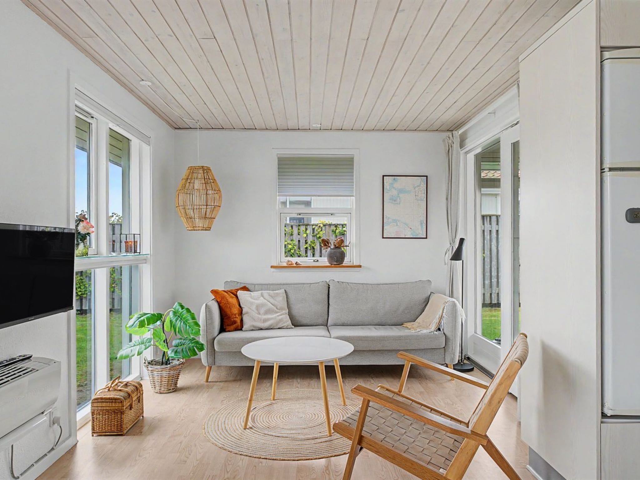 A modern living room with a grey sofa, a round coffee table, and a television.