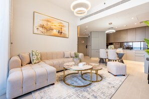 A modern living room with a sofa, two side tables, and a painting on the wall. - Sky Level 1BR with Balcony Overlooking the Canal, Short Drive from Burj Khalifa (Dubai)