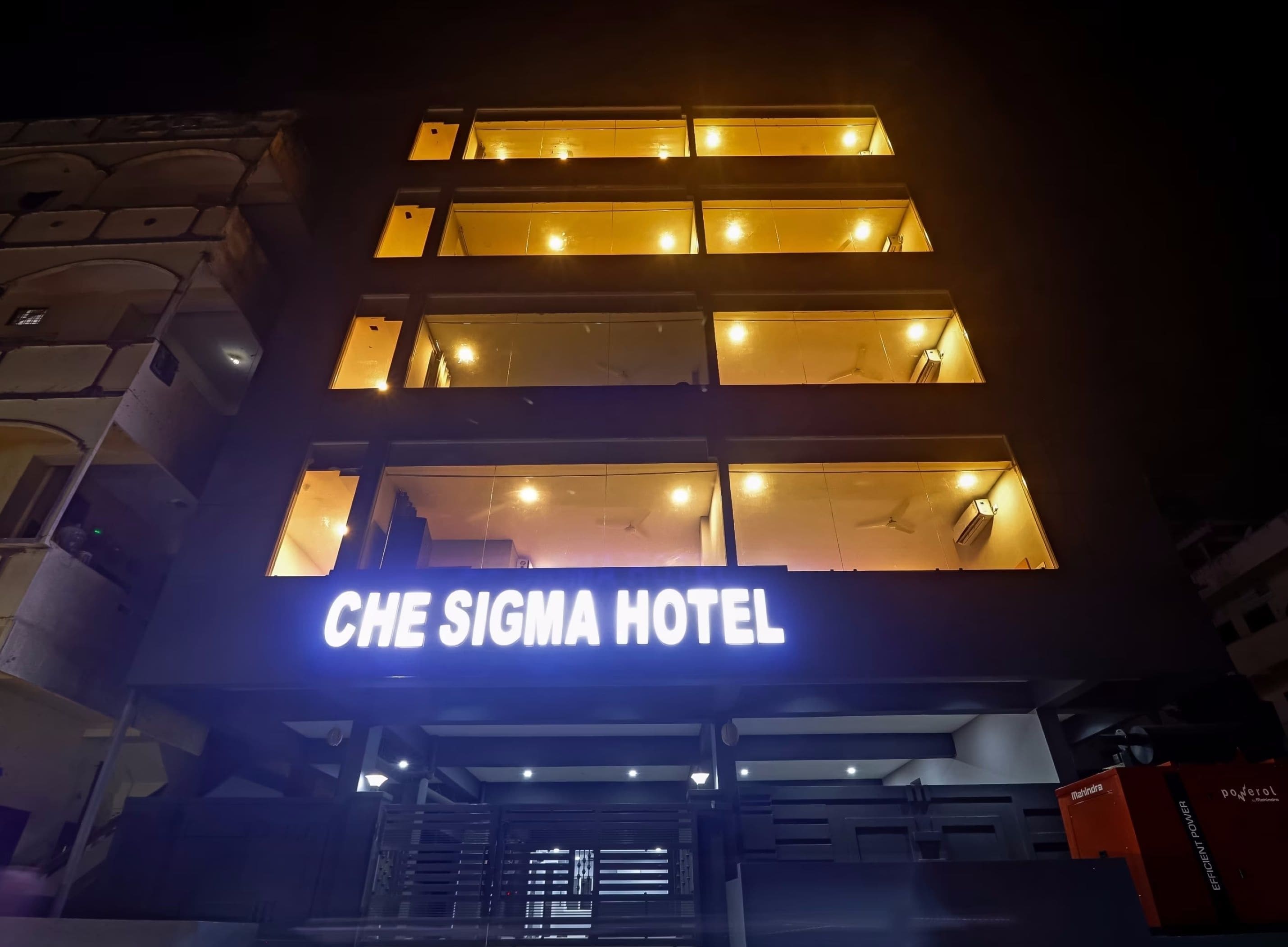 Ein Hotel mit einem gut sichtbaren Schild mit der Aufschrift 'CHE SIGMA HOTEL' und mehreren beleuchteten Fenstern.