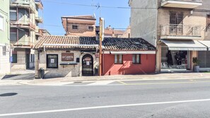 A building with a tiled roof, a storefront with a sign, and a sidewalk. - Apartments 1889 - Cozy Studio Apartment Just a Few Meters from the Sea in Porto Sant'Elpidio (Porto Sant`Elpidio)
