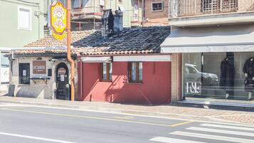A building with a red facade, a tiled roof, and a storefront with a sign that reads 'LA CASETTA.'