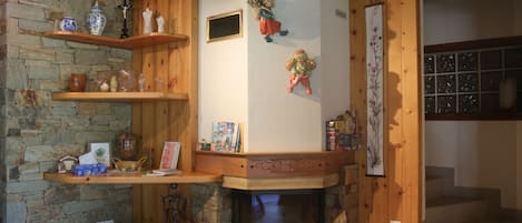 Una habitación acogedora con chimenea de piedra, estantes de madera y un ventanal.