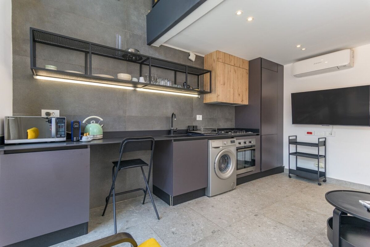A modern kitchen with a built-in washing machine, a microwave, and a stove.
