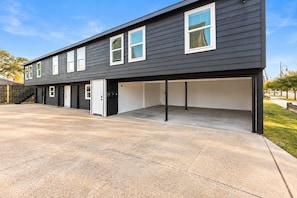 A two-story building with a covered garage and a concrete driveway. - 2BR Near TSU and Med Center I Assigned Parking 4 (Houston)