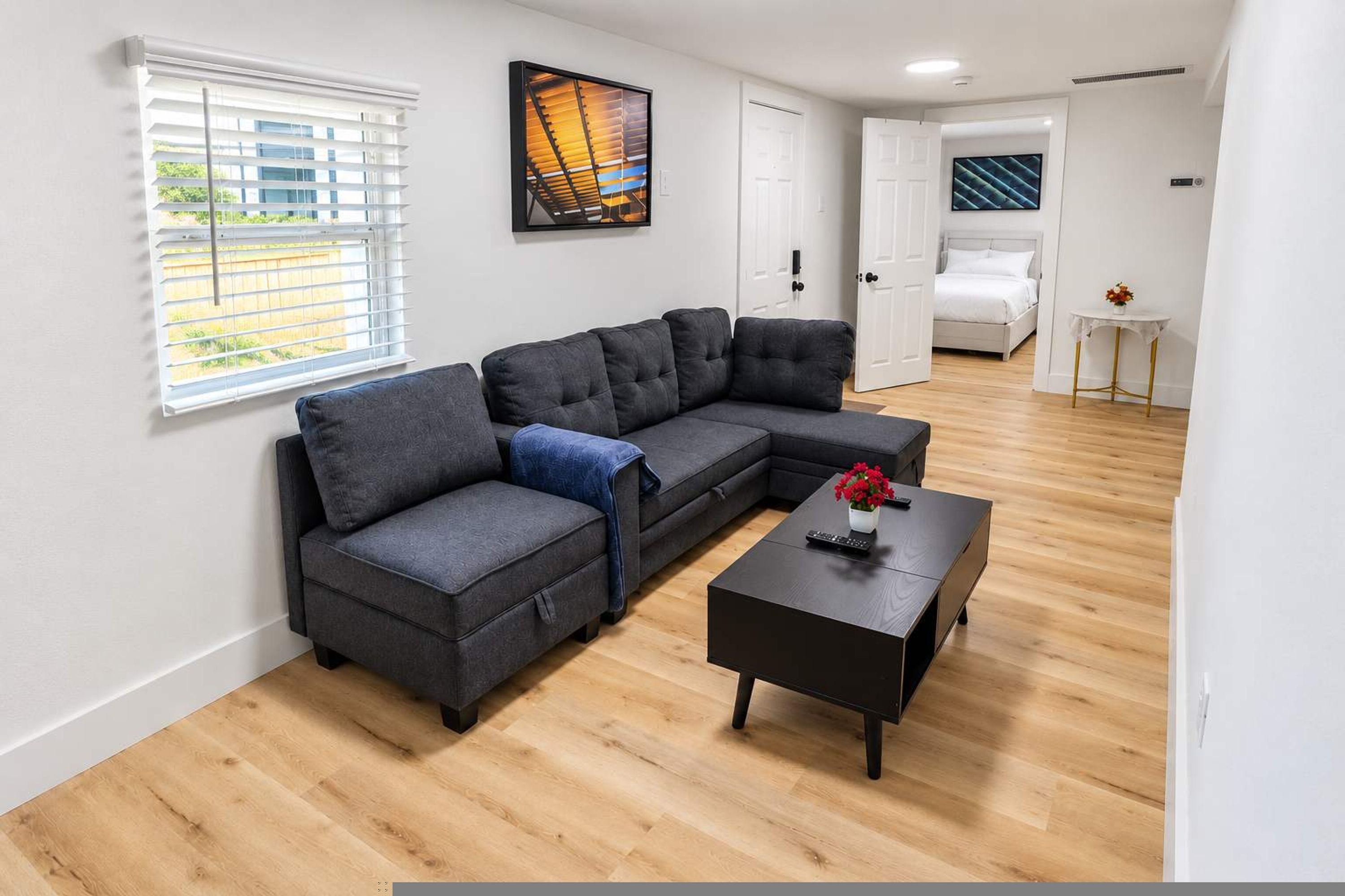Una sala de estar moderna con un sofá modular, una mesa de centro y un cuadro en la pared.