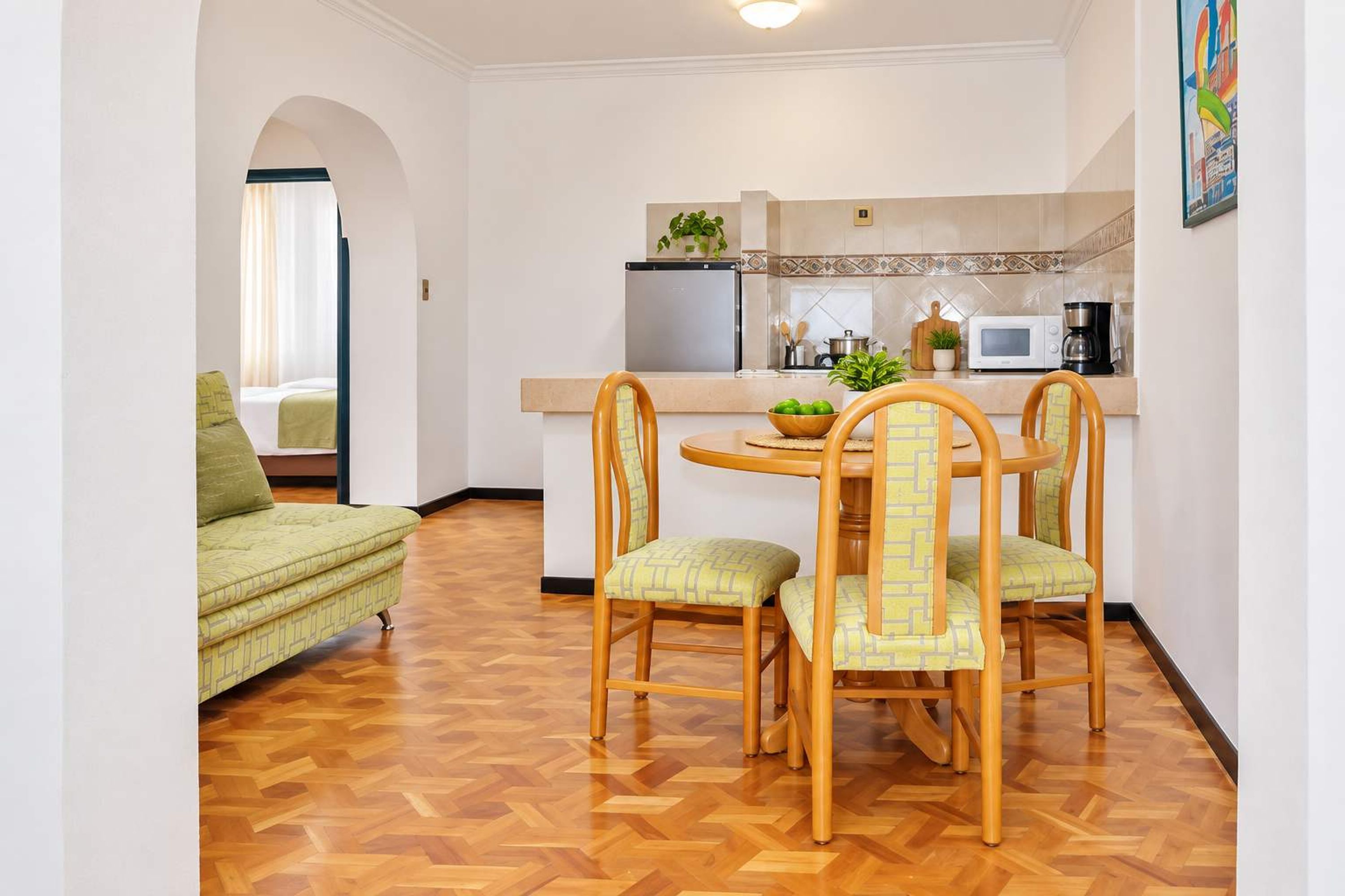 A compact living space with a dining area, kitchenette, and a sofa.