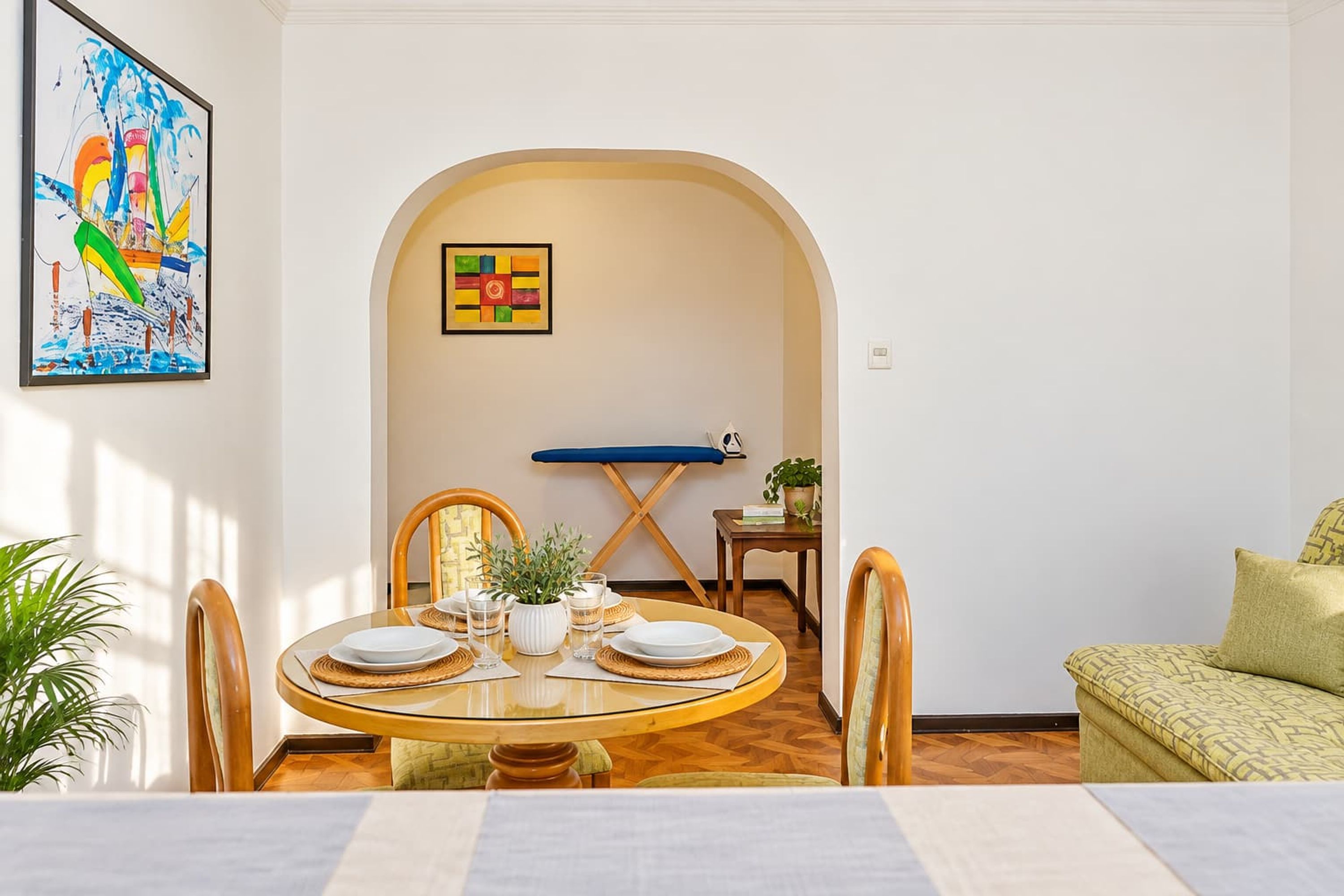 A dining area with a round table, chairs, and a small potted plant.