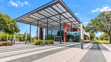 A modern building with a glass facade and a metal roof structure.