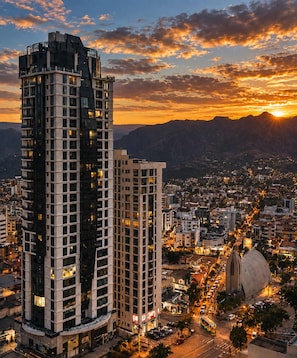 A high-rise building with multiple floors, surrounded by a cityscape at sunset. - Calacoto Apt Kitchenette Zona Sur Sleeps 2 (La Paz)