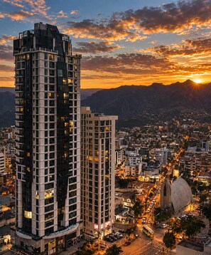 A high-rise building with multiple floors, surrounded by a cityscape at sunset. - Calacoto Queen Suite Sleeps 4 Zona Sur Wi-fi (La Paz)