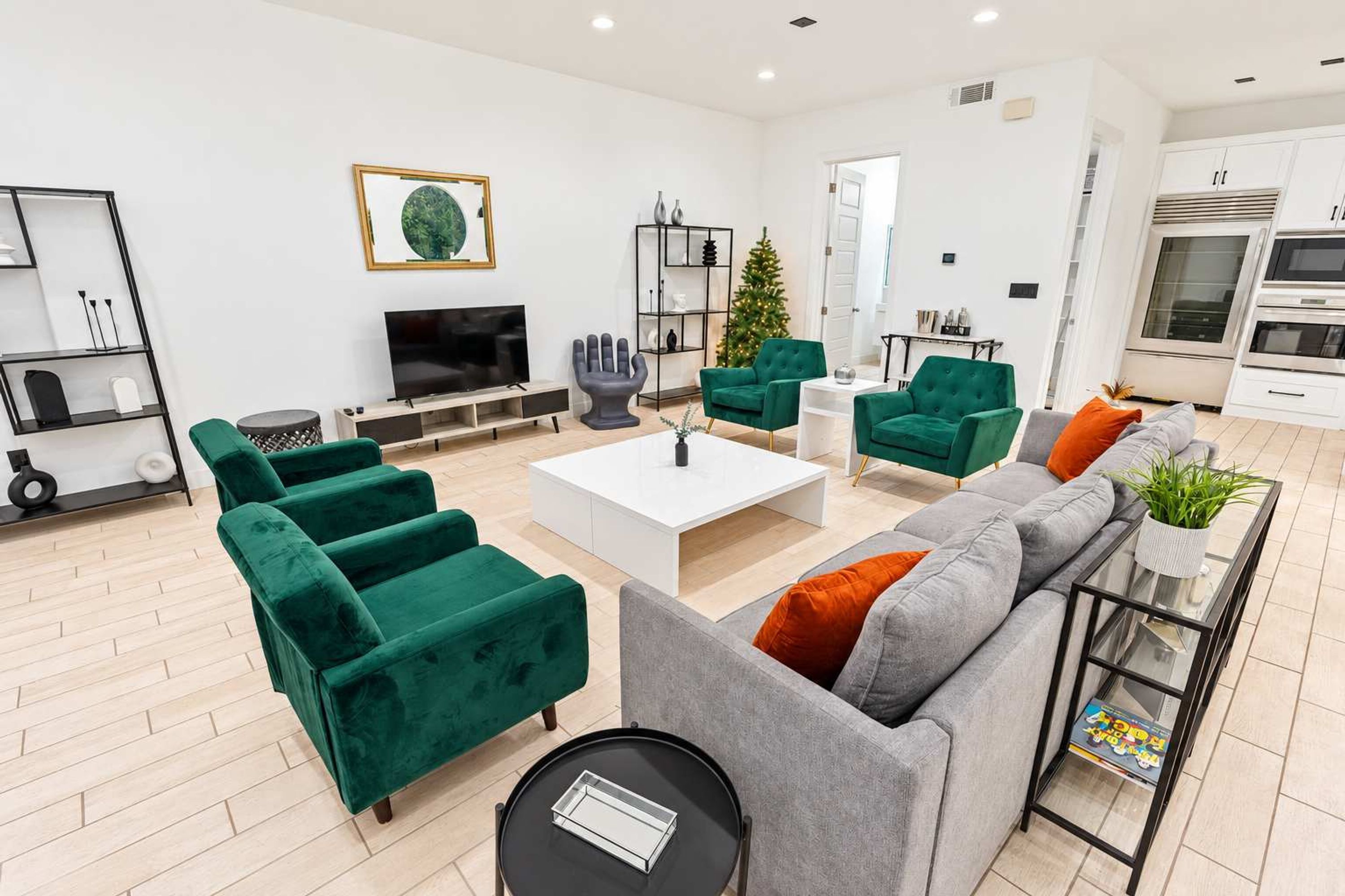 A modern living room with green and grey sofas, a coffee table, and a TV.