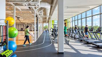 A gym with exercise equipment, treadmills, and a running track.