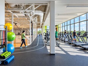 Une salle de sport équipée de matériel d’exercice, de tapis de course et d’une piste d’athlétisme.