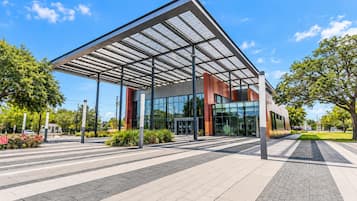 A modern building with a glass facade and a metal roof structure.