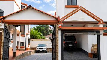 A gated driveway leading to a garage with a vehicle parked inside.