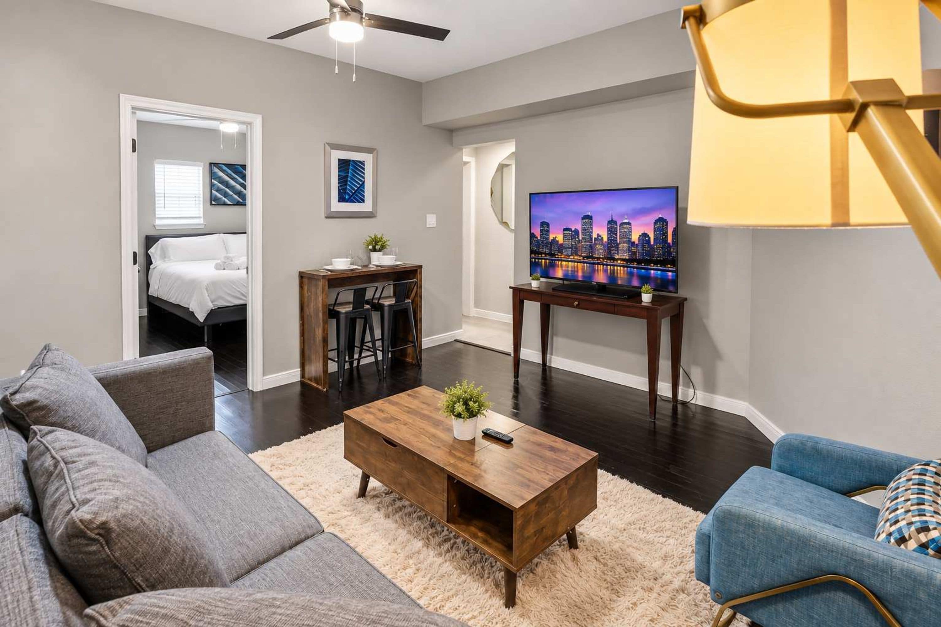 A modern living room with a sofa, coffee table, and a TV on a stand.