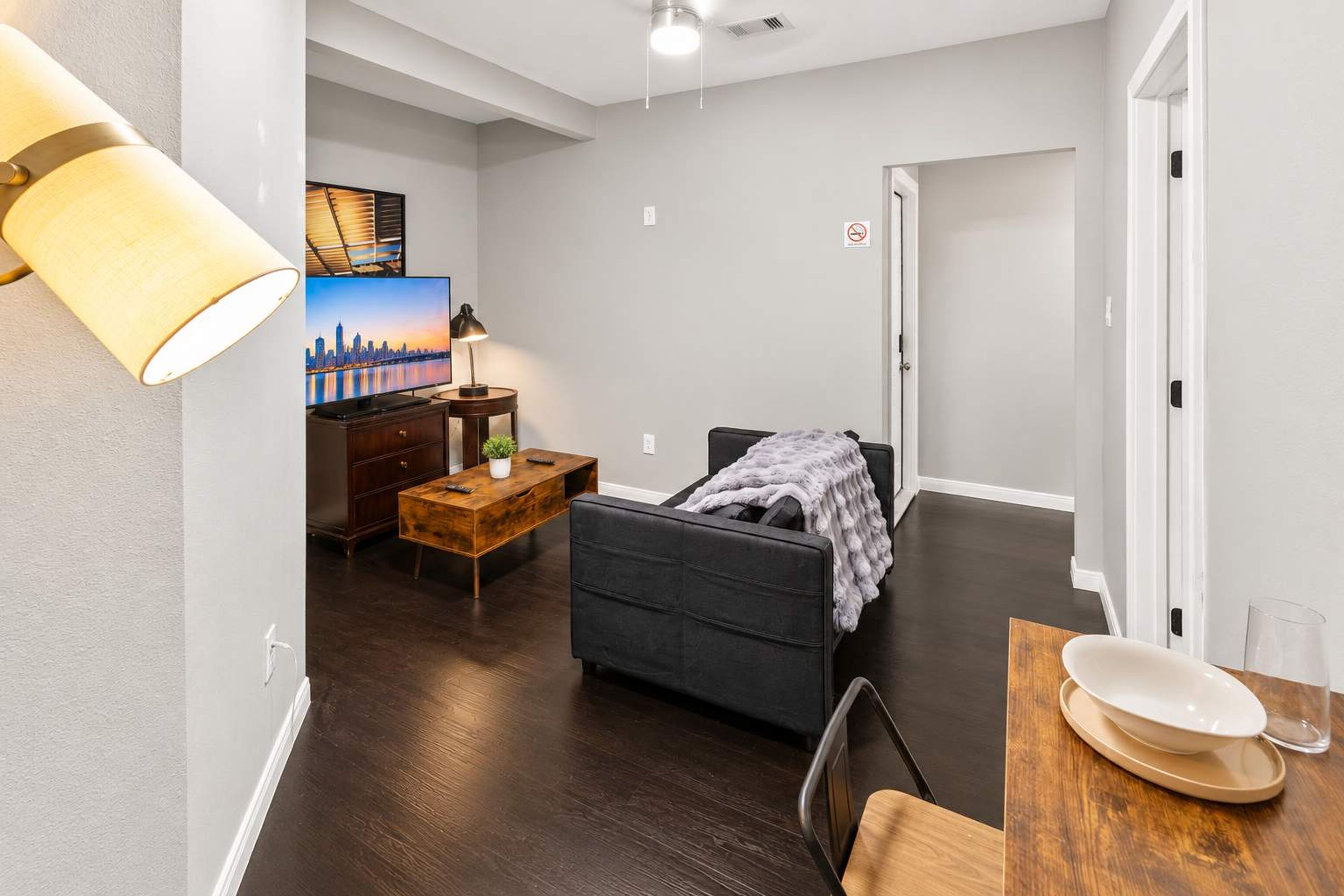 A modern living room with a sofa, a coffee table, and a TV.