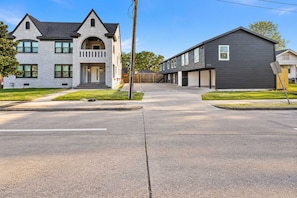 A residential street with two houses, one with a grey facade and a pitched roof, and the other with a dark grey facade and a flat roof. - Fifa Stay 2BR Near NRG DT Med Center -3 (Houston)