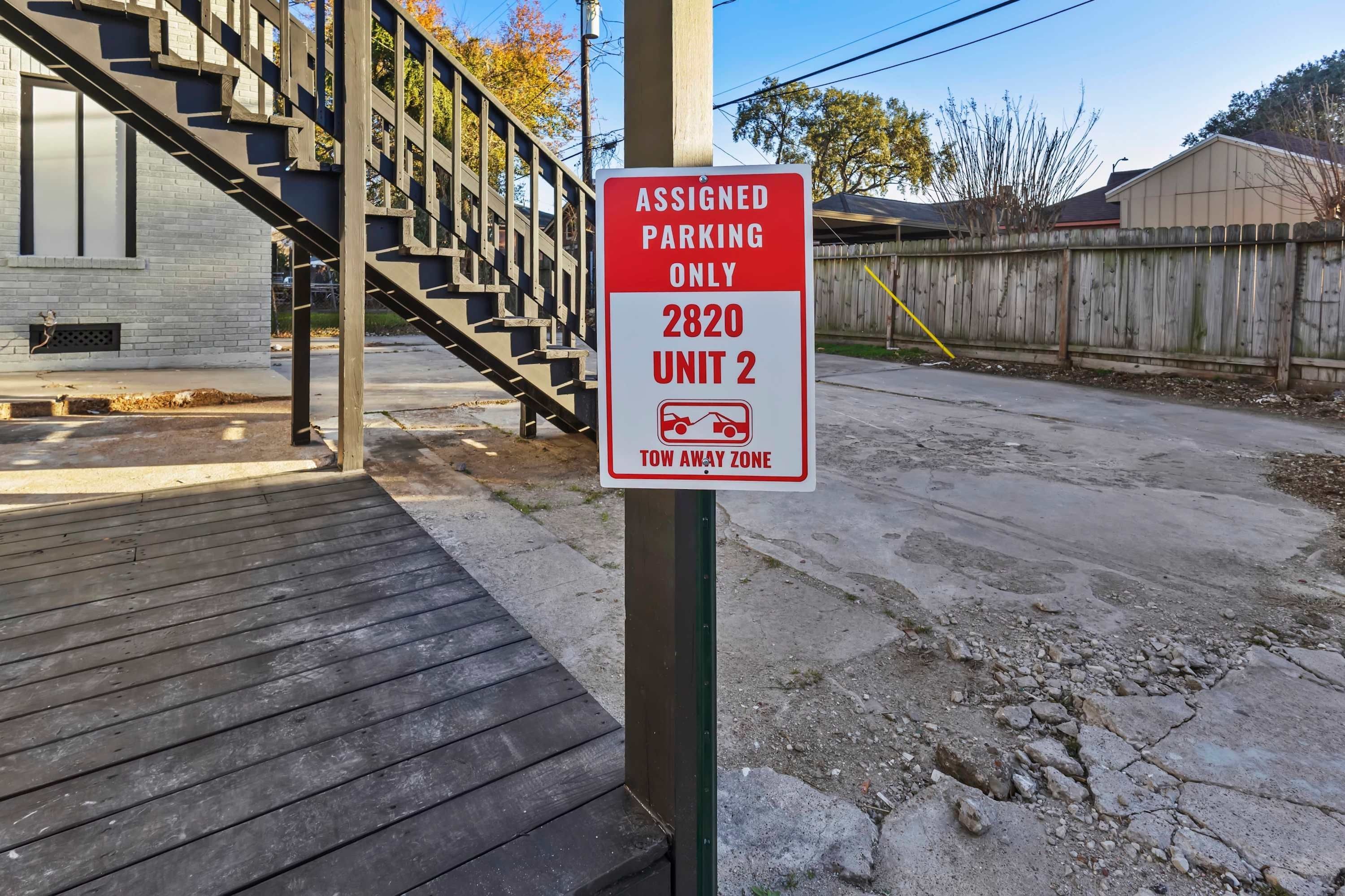 A parking sign indicating assigned parking for unit 2820, unit 2, and a tow away zone.