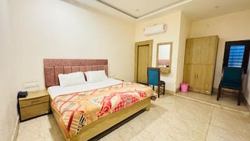 Una habitación de hotel con cama, mesita de noche, armario y espejo.