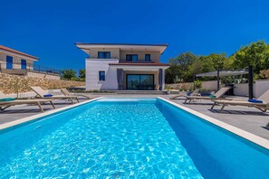 A modern two-story house with a swimming pool, outdoor seating, and a stone retaining wall. - Villa Adria Moments With Private Pool (Krk)