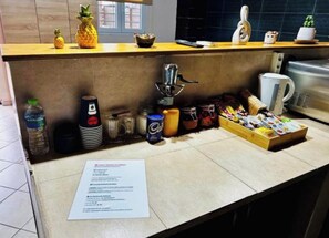 A kitchen counter with a coffee machine, a paper, and various food items.