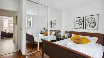 Una camera d'albergo con un letto grande, uno specchio e opere d'arte alle pareti.