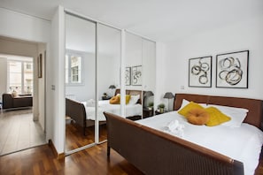 Ein Hotelzimmer mit einem großen Bett, einem Spiegel und Bildern an den Wänden.
