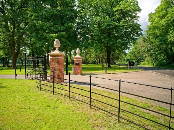 A gated entrance with a brick wall and a metal fence. - Tyrrells Park (Christchurch)
