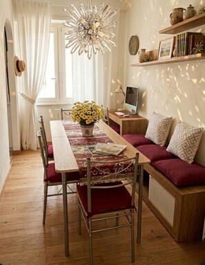A cozy living room with a dining table, a sofa, and a TV. - Aura Luxury Apartment: Sleeps 7, Garden, Parking, Near St. Peter's & Metro (Roma)