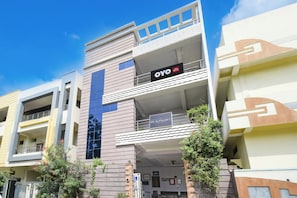 A modern building with a sign for 'OYO' and 'De Alphabet Luxury Hotels'. - Hotel O De Alphabet Home Stays NTPC  (Ramagundam)