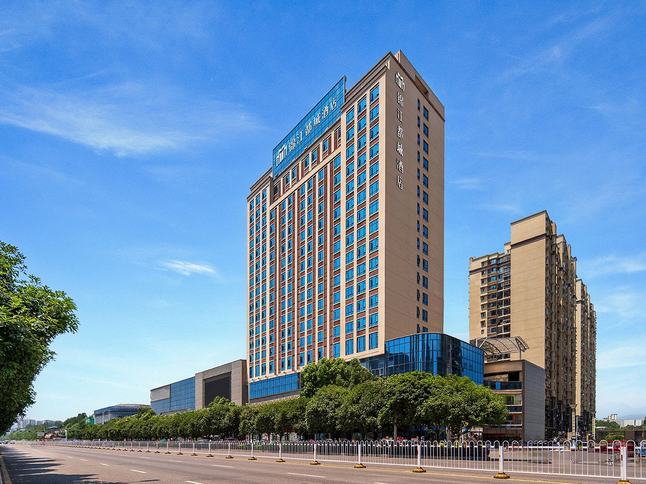 Un hotel moderno de gran altura, con varias plantas y un llamativo letrero azul.