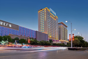 A multi-story hotel with a modern facade, large windows, and a prominent sign.