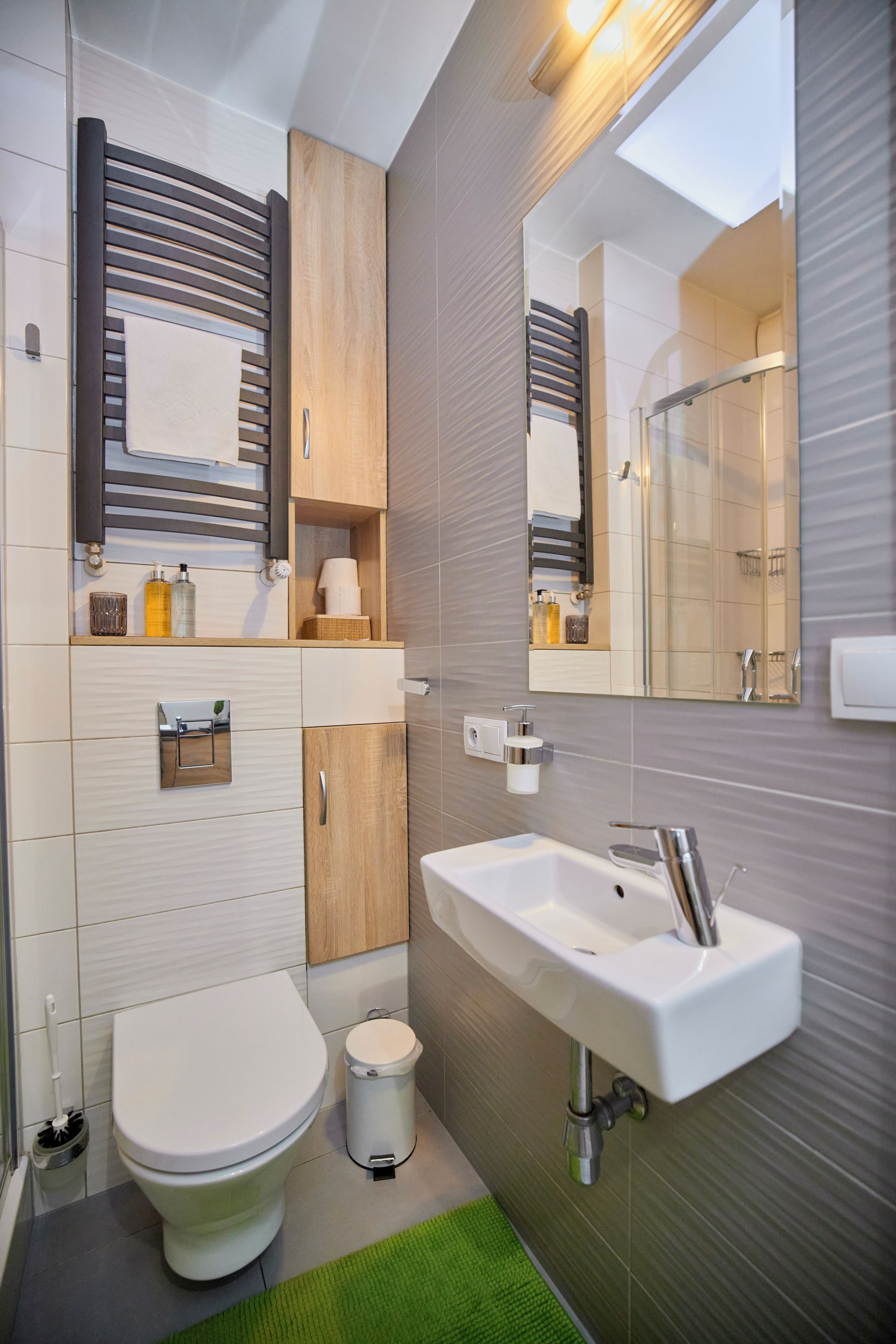Un baño moderno con inodoro, lavamanos y espejo.