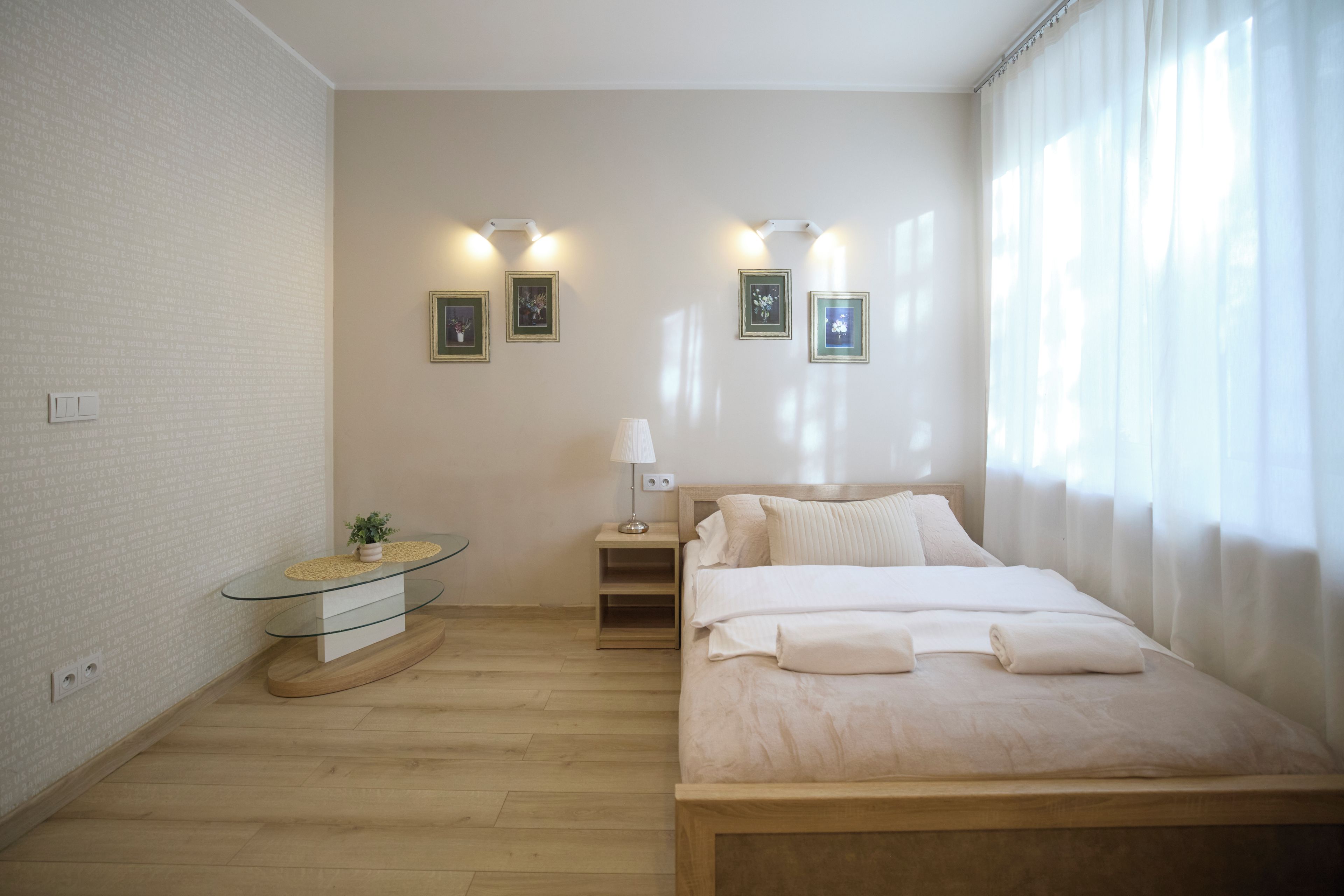 Un dormitorio con cama, mesita de noche, lámpara y luces en la pared.
