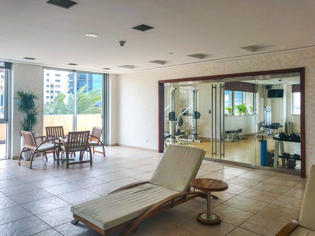 A spacious indoor area with a lounge chair, a small round table, and a dining set.