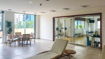 A spacious indoor area with a lounge chair, a small round table, and a dining set.