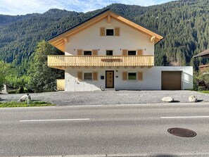 Ein zweistöckiges Gebäude mit einem Balkon, einer Holztür und einem Schild, auf dem 'The Husky Lodge' steht.