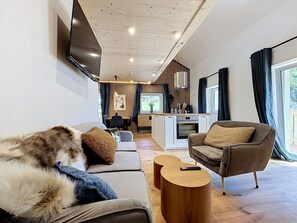 Ein modernes Wohnzimmer mit Sofa, Sessel und Couchtisch.