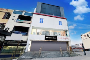 Un edificio de varios pisos con una fachada comercial en la planta baja.