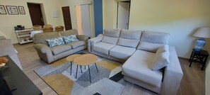 A living room with two sofas, a coffee table, and a patterned rug.